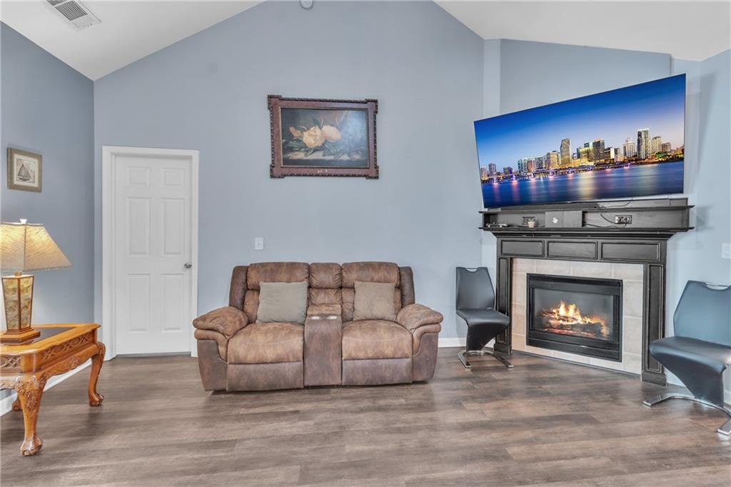 4044 Amberleigh Trace Gainesville, GA 30507 - Photo 6 of 21 a living room with furniture a fireplace and a flat screen tv