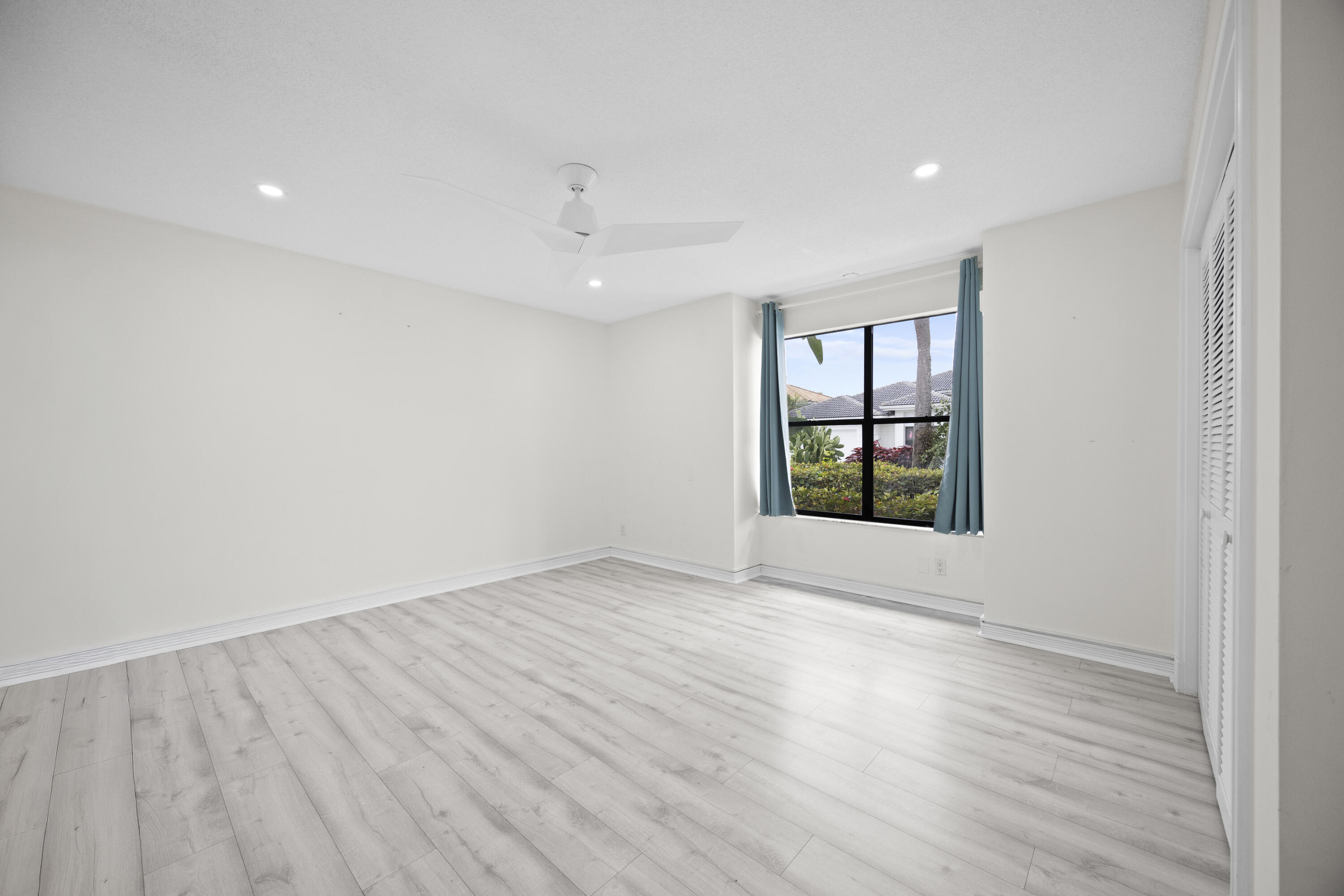 10106 Spyglass Way Boca Raton, FL 33498 - Photo 19 of 56 an empty room with wooden floor and windows