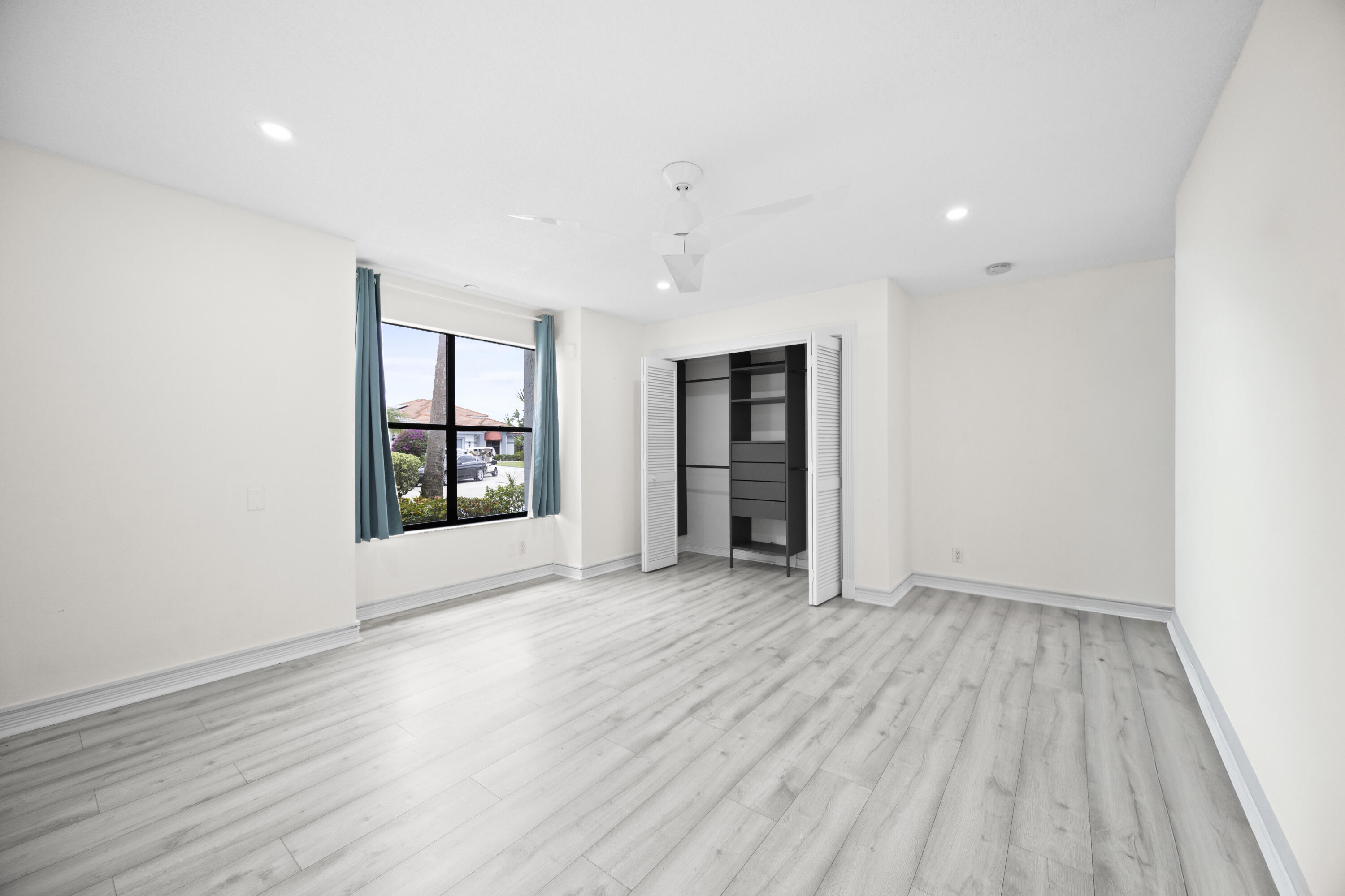 10106 Spyglass Way Boca Raton, FL 33498 - Photo 20 of 56 an empty room with wooden floor and windows