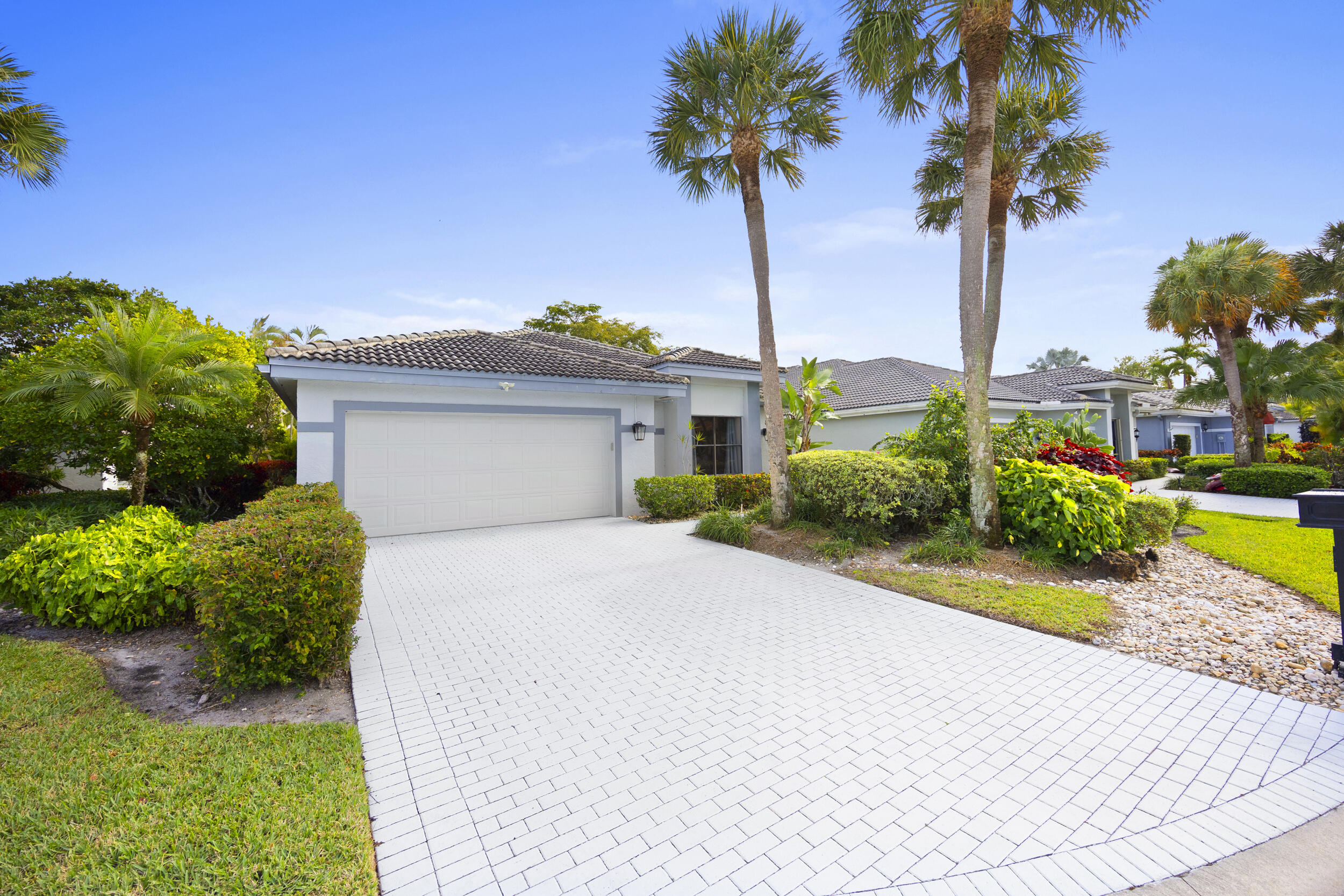 10106 Spyglass Way Boca Raton, FL 33498 - Photo 3 of 56 a front view of a house with a garden and a tree