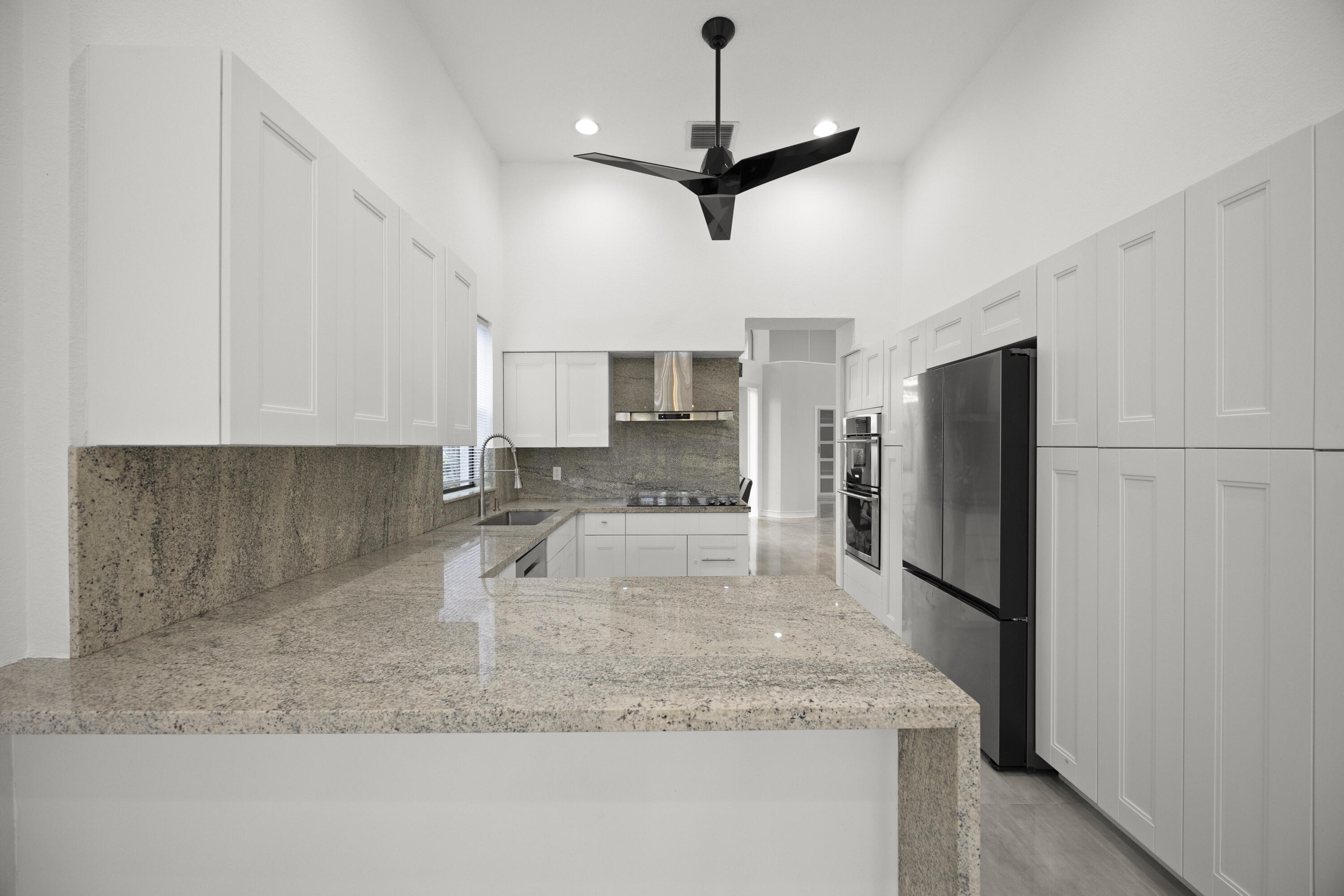 10106 Spyglass Way Boca Raton, FL 33498 - Photo 35 of 56 a kitchen with stainless steel appliances granite countertop a sink a refrigerator and a granite counter tops