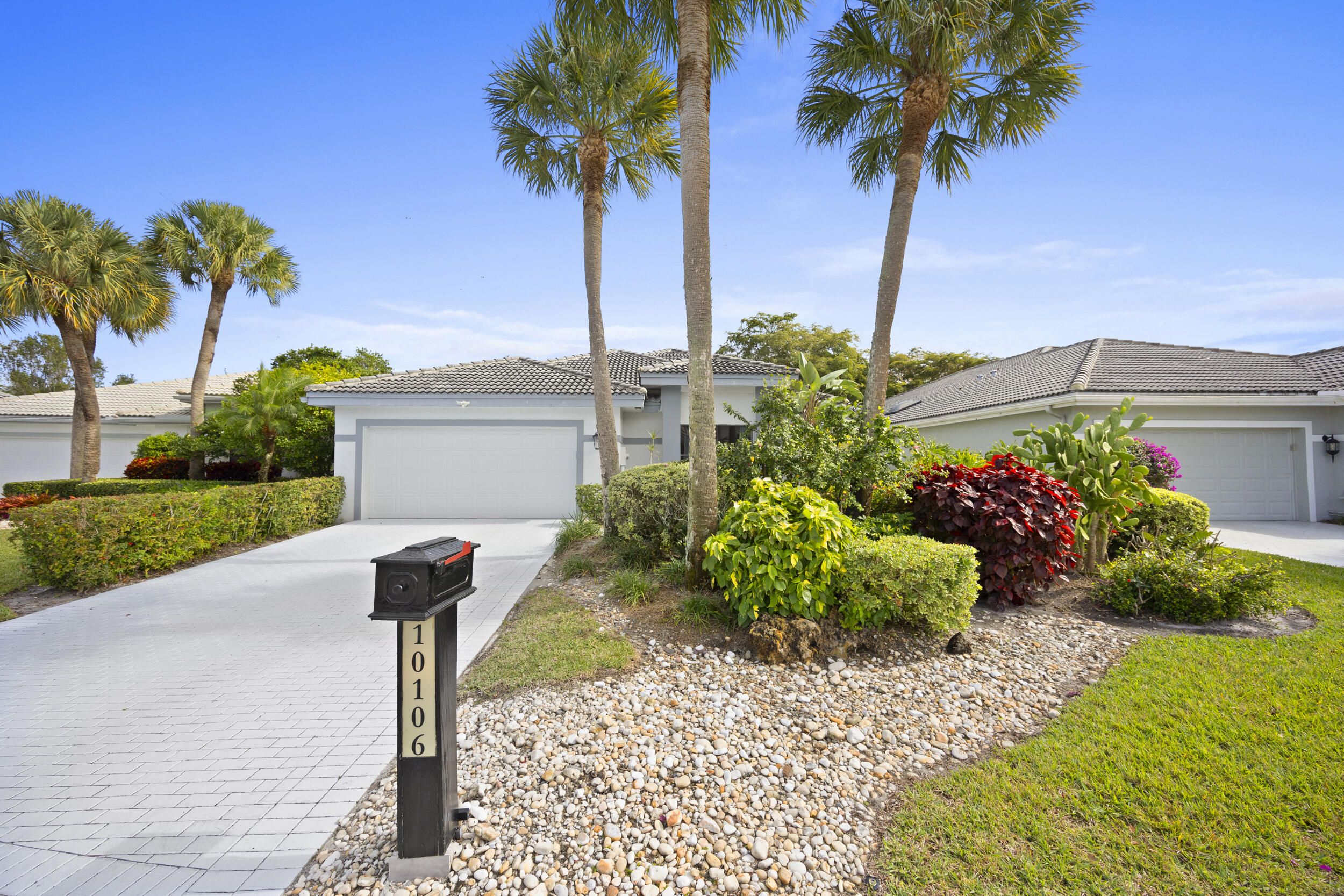 10106 Spyglass Way Boca Raton, FL 33498 - Photo 52 of 56 a front view of a house with a yard and potted plants