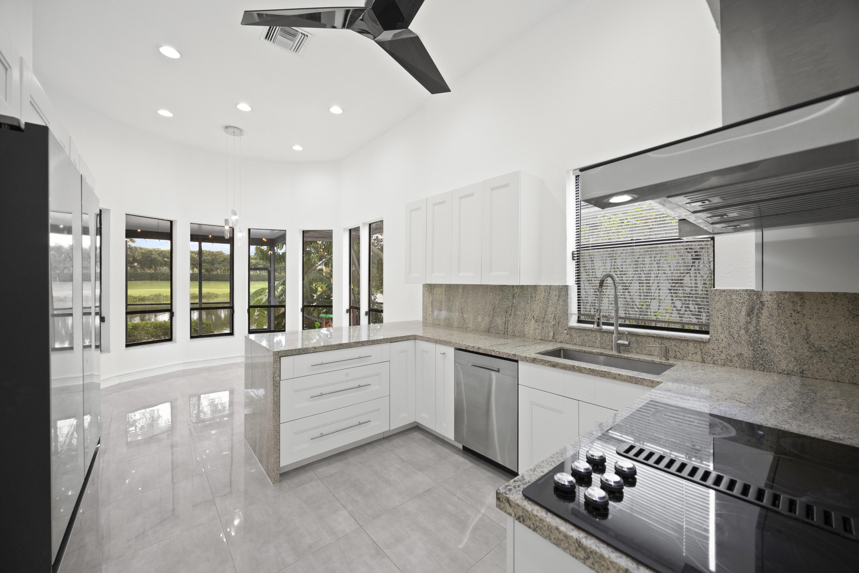 10106 Spyglass Way Boca Raton, FL 33498 - Photo 7 of 56 a kitchen with stainless steel appliances kitchen island granite countertop a sink and cabinets