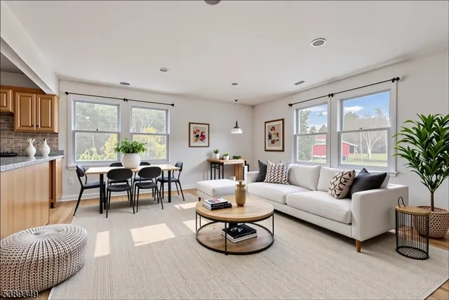 a living room with furniture a large window and a table