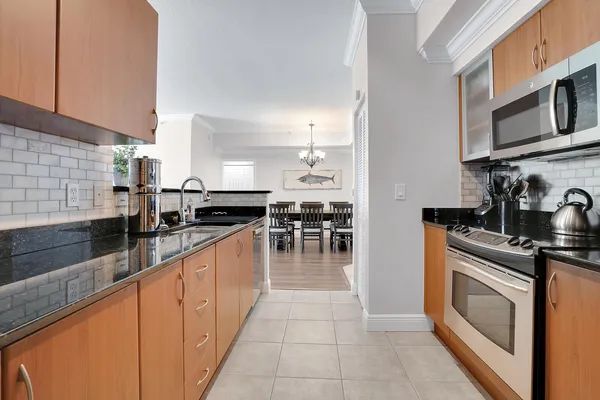 a large kitchen with stainless steel appliances granite countertop a stove and a sink