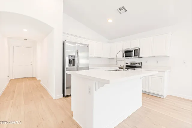 a kitchen with a sink cabinets and wooden floor