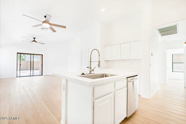 a kitchen with stainless steel appliances white cabinets and a stove top oven