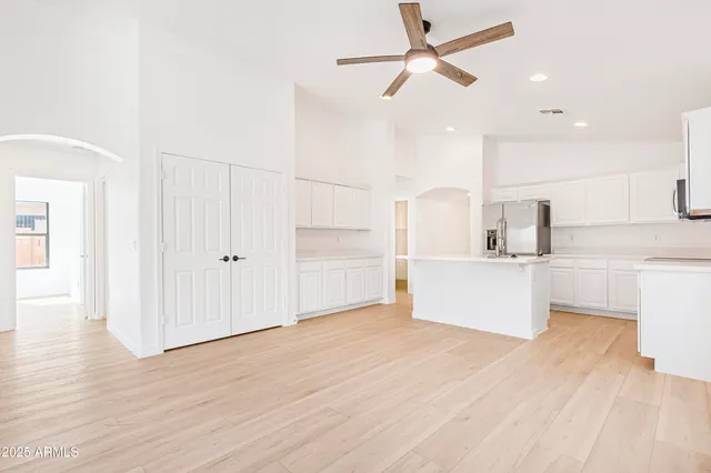 a view of a hallway with a chandelier fan and wooden floor