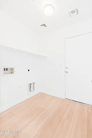 a view of a hallway with wooden floor and closet