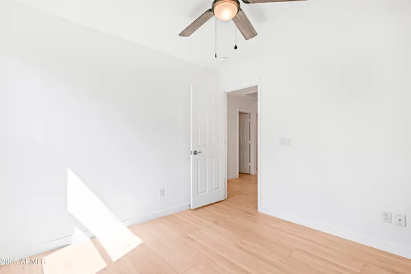 an empty room with a window and a fan
