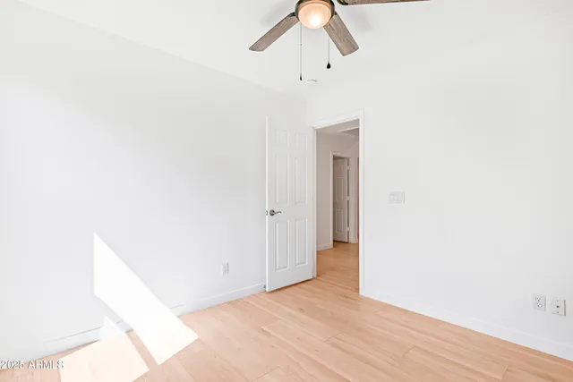 an empty room with a window and a fan