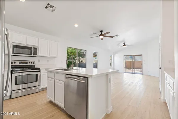 a kitchen with kitchen island a sink appliances and cabinets