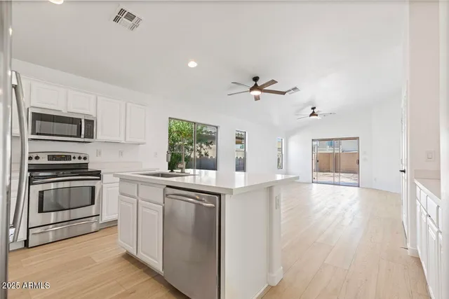 a kitchen with kitchen island a sink appliances and cabinets
