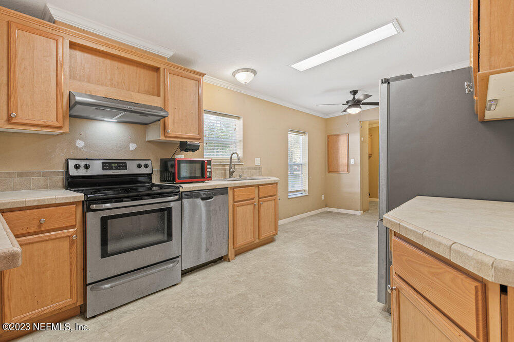 18066 Wells Road Jacksonville, FL 32234 - Photo 13 of 50 a kitchen with a stove microwave and a refrigerator