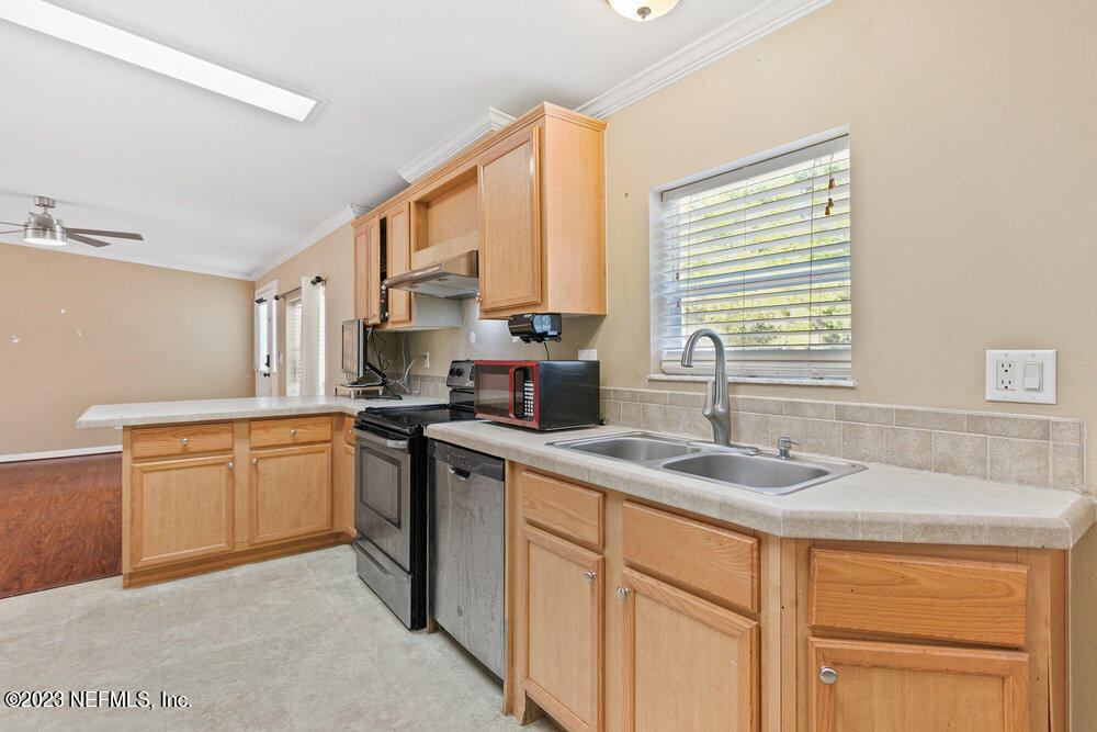 18066 Wells Road Jacksonville, FL 32234 - Photo 18 of 50 a kitchen with stainless steel appliances granite countertop a sink stove and cabinets
