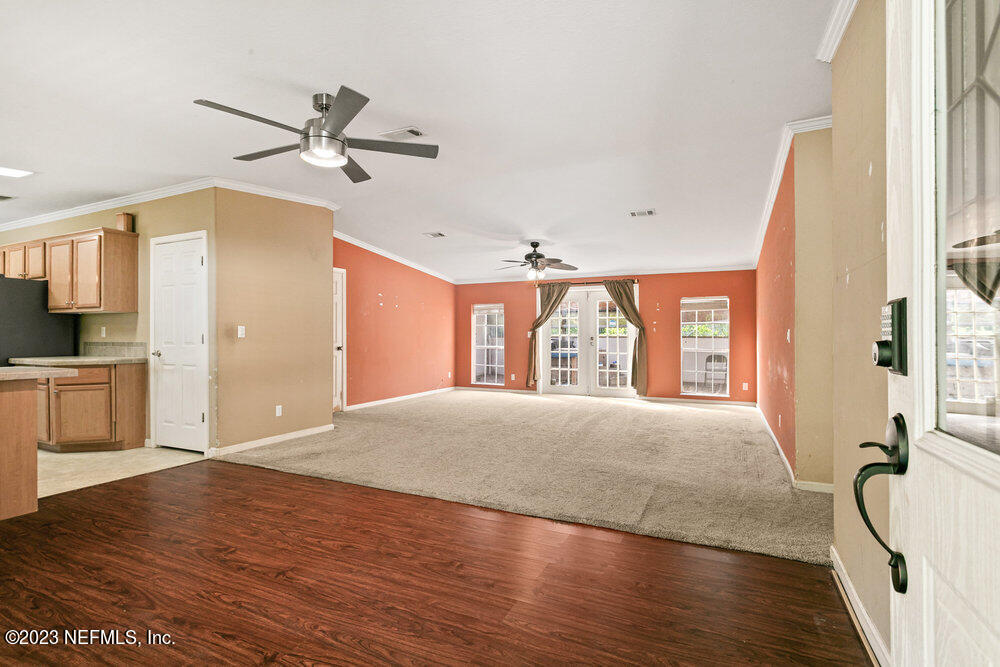 18066 Wells Road Jacksonville, FL 32234 - Photo 20 of 50 a spacious bedroom with a large bed a chandelier and windows