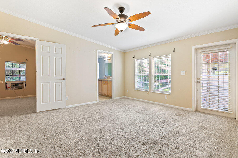 18066 Wells Road Jacksonville, FL 32234 - Photo 25 of 50 an empty room with chandelier fan and windows