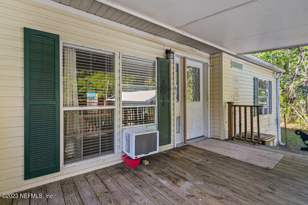 18066 Wells Road Jacksonville, FL 32234 - Photo 10 of 50 an empty room with wooden floor and windows