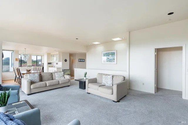 a kitchen with stainless steel appliances granite countertop a refrigerator a stove and a dining table with wooden floor