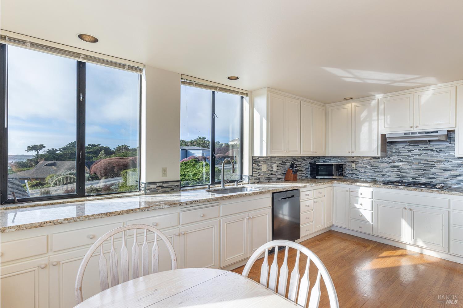 150 Cypress Loop Bodega Bay, CA 94923 - Photo 19 of 62 a kitchen with stainless steel appliances granite countertop a stove a sink and a granite counter tops with white cabinets next to a window