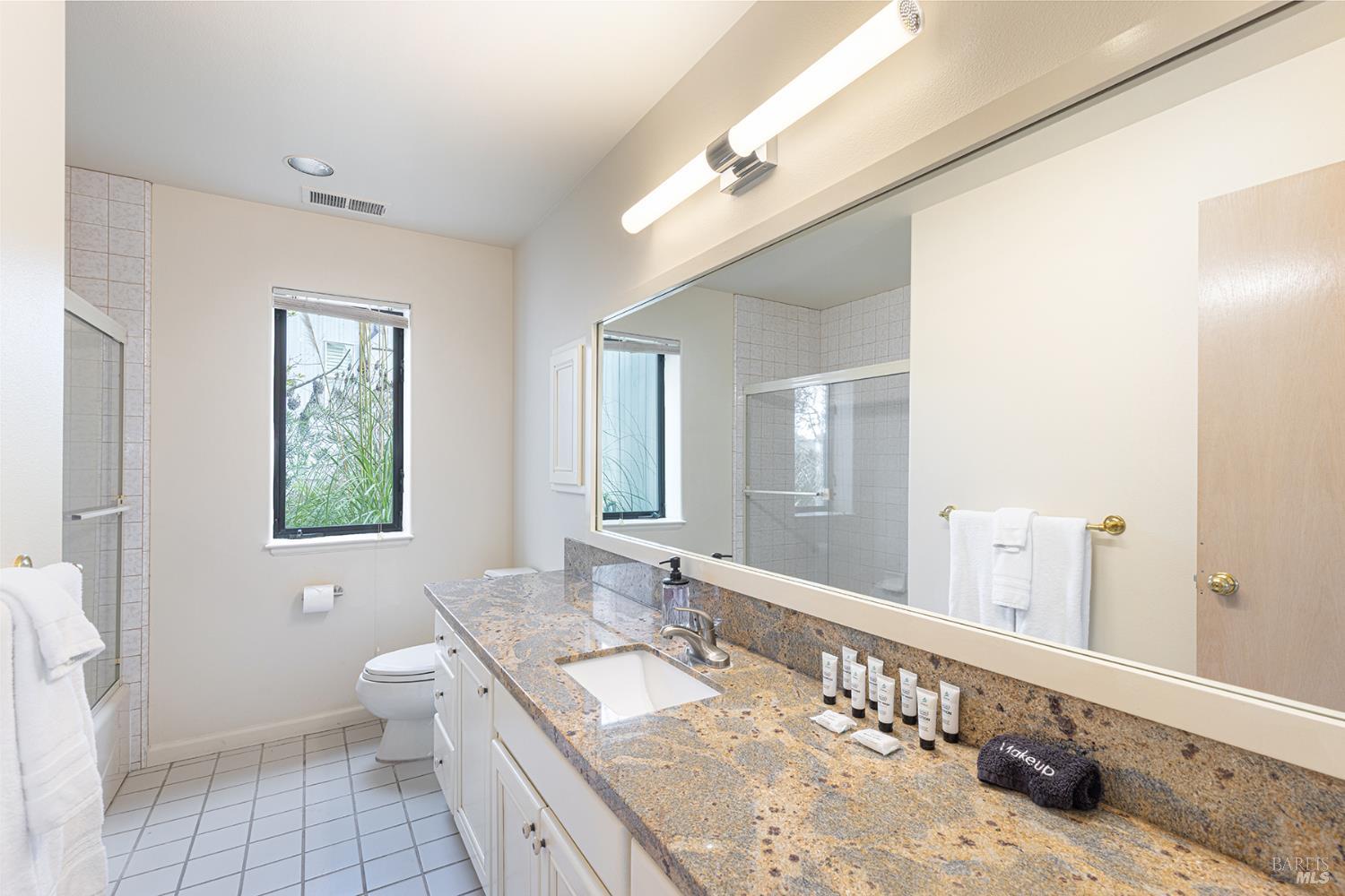 150 Cypress Loop Bodega Bay, CA 94923 - Photo 43 of 62 a bathroom with a granite countertop double vanity sink a mirror and a toilet