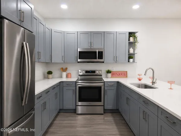 a kitchen with stainless steel appliances granite countertop a stove top oven a sink and dishwasher