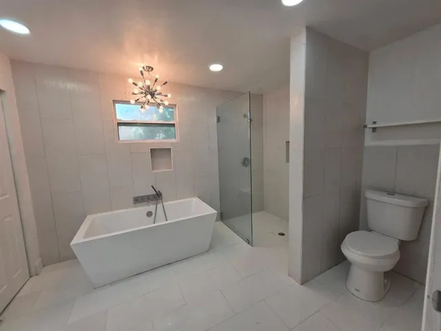 a spacious bathroom with a bathtub a toilet a sink and a shower