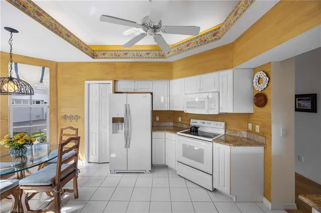 a kitchen with cabinets and chairs