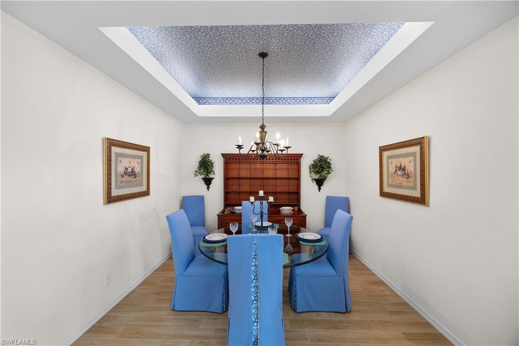 1826 Seville Boulevard, Unit 1012 Naples, FL 34109 - Photo 17 of 50 a view of a dining room with furniture wooden floor and chandelier