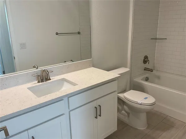 a bathroom with a granite countertop toilet sink and mirror