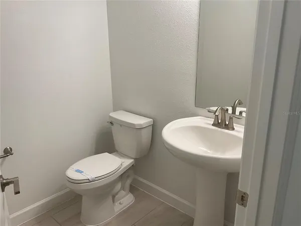 a white toilet sitting next to a white sink