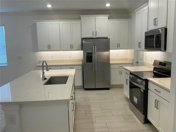 a kitchen with a sink appliances and cabinets