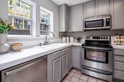 a kitchen with stainless steel appliances granite countertop a sink stove and microwave