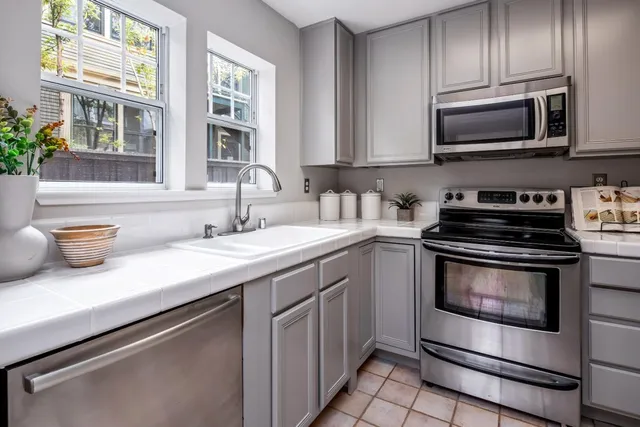 a kitchen with stainless steel appliances granite countertop a sink stove and microwave
