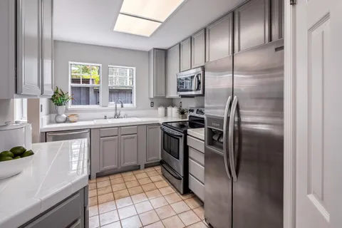 a kitchen with a refrigerator sink and cabinets