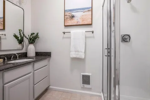 a bathroom with a granite countertop sink a mirror and vanity