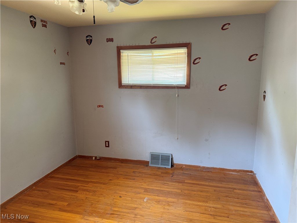 6350 Meadowbrook Road Garfield Heights, OH 44125 - Photo 23 of 28 Empty room with light wood finished floors and a ceiling fan