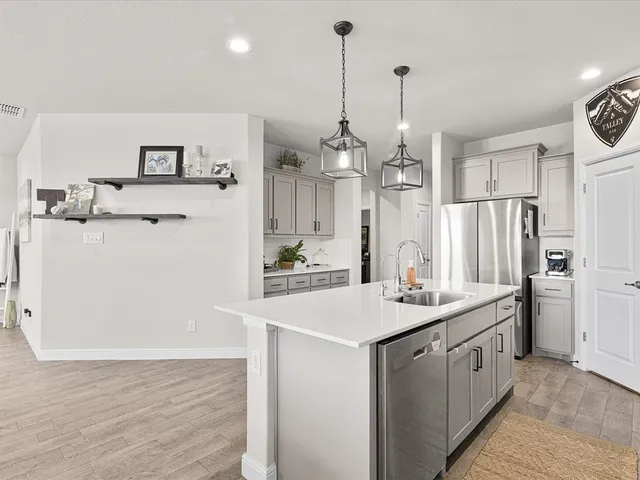 a kitchen with stainless steel appliances a sink stove and refrigerator