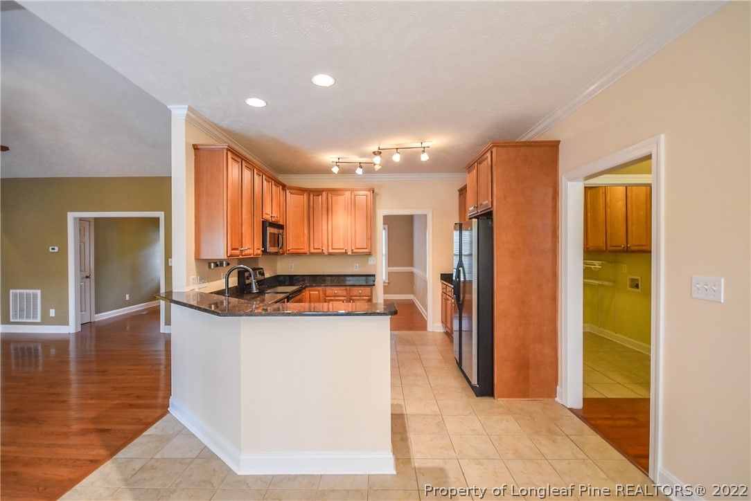 36 Falling Water Road Spring Lake, NC 28390 - Photo 15 of 50 a view of a kitchen with kitchen island granite countertop a refrigerator and a sink