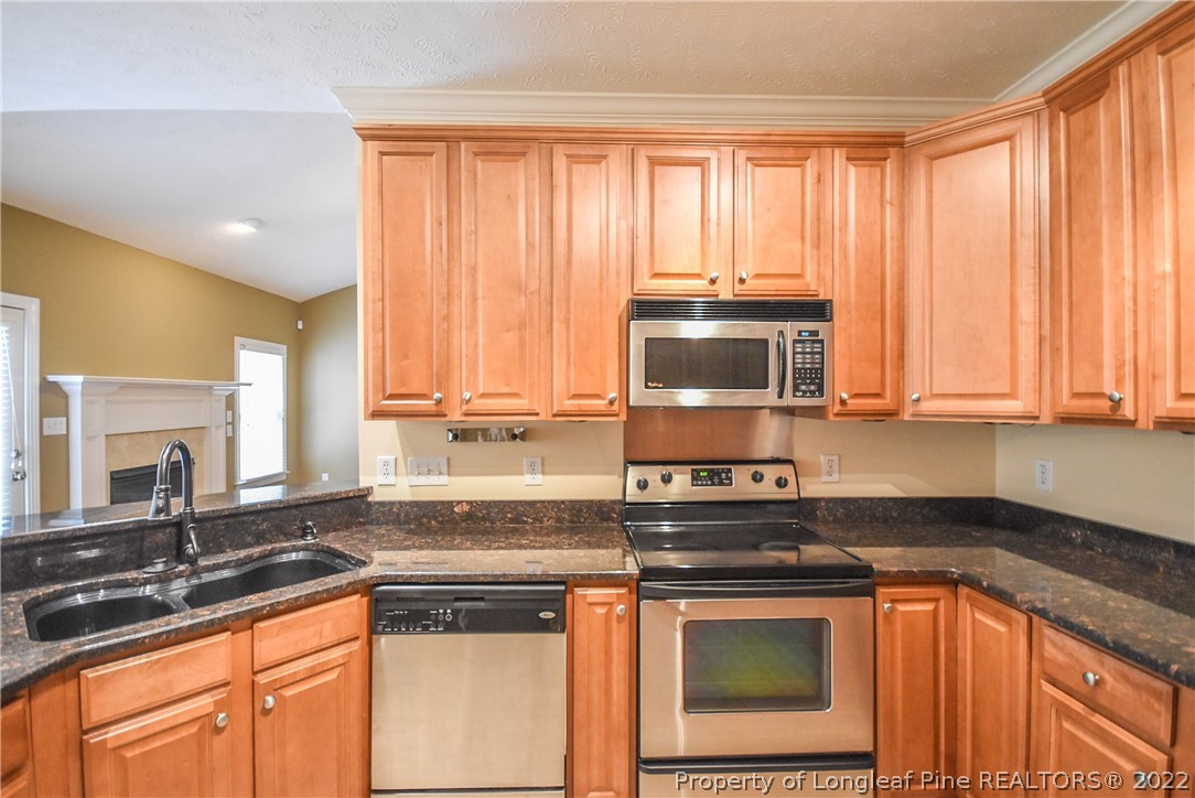 36 Falling Water Road Spring Lake, NC 28390 - Photo 17 of 50 a kitchen with stainless steel appliances granite countertop a stove a sink and a microwave