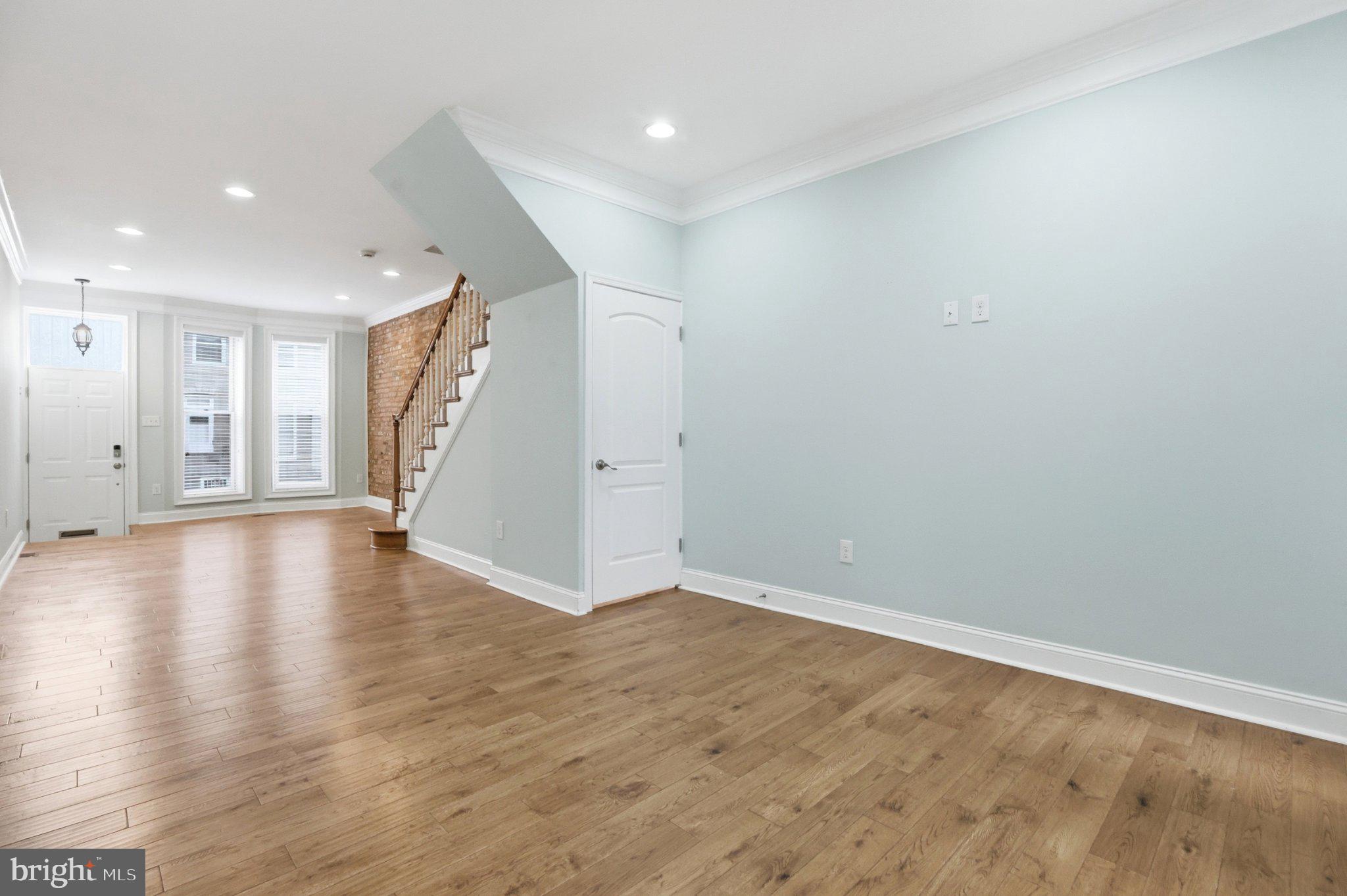 222 South Exeter Street Baltimore, MD 21202 - Photo 12 of 41 a view of a livingroom with wooden floor and staircase