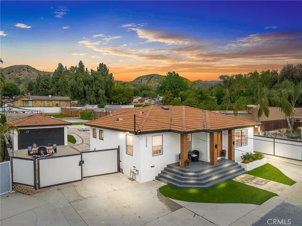a view of a white house with a sink and fire pit