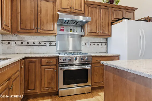 a kitchen with stainless steel appliances granite countertop a stove and a refrigerator