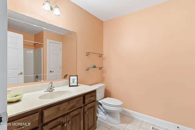 a bathroom with a granite countertop sink a toilet and a mirror