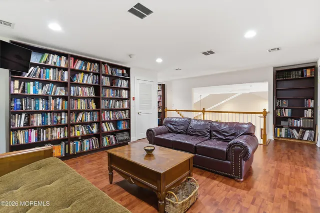 a living room with furniture and a book shelf