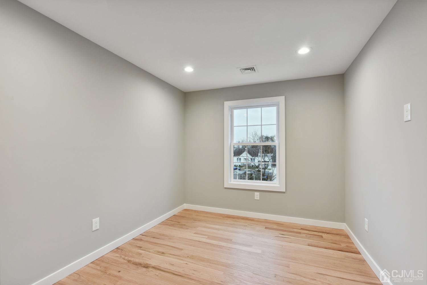 13 Albany Street Edison, NJ 08837 - Photo 19 of 26 an empty room with wooden floor and windows
