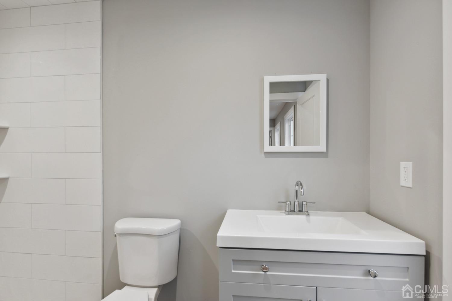 13 Albany Street Edison, NJ 08837 - Photo 22 of 26 a bathroom with a toilet a sink and mirror