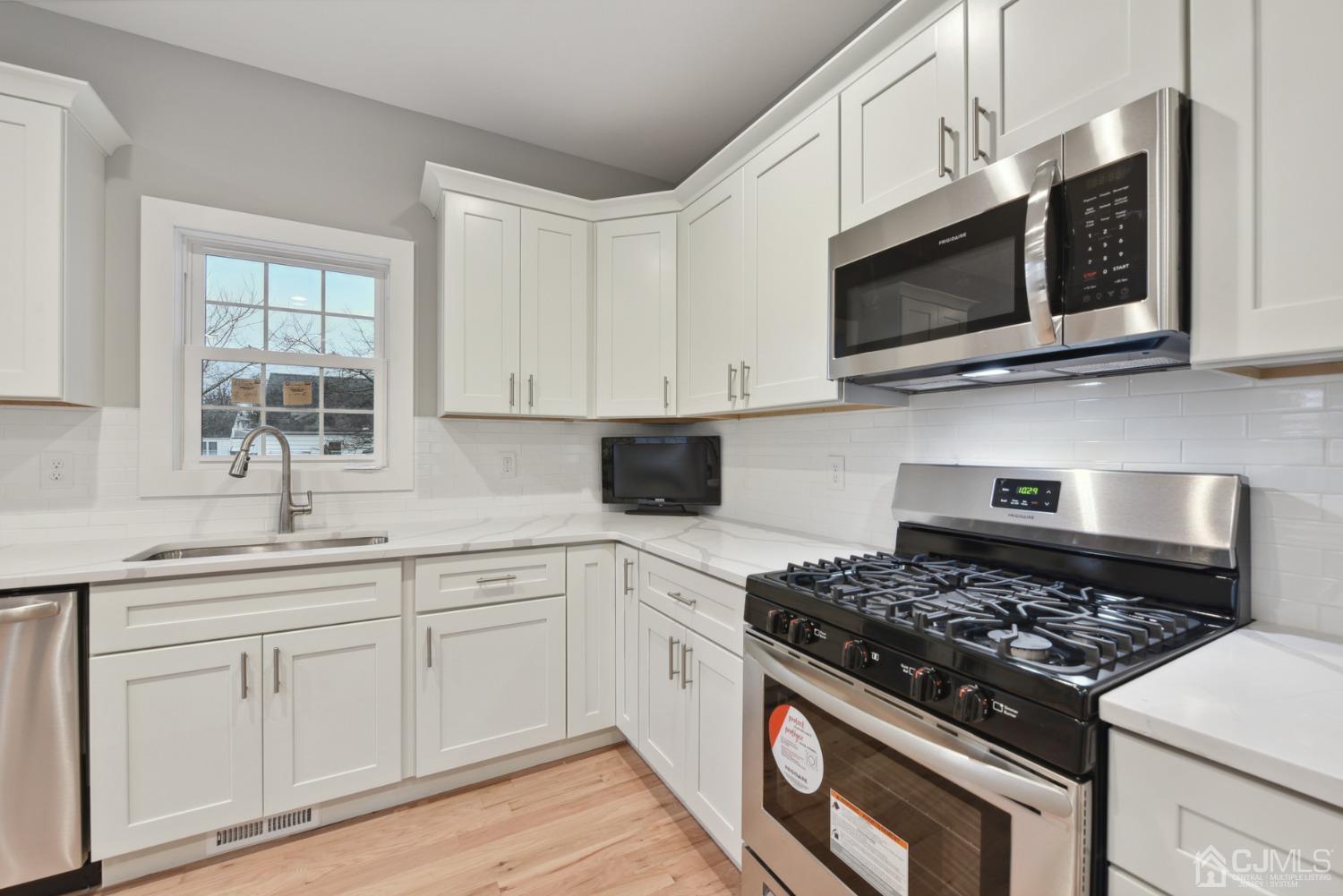 13 Albany Street Edison, NJ 08837 - Photo 8 of 26 a kitchen with stainless steel appliances white cabinets and a stove top oven