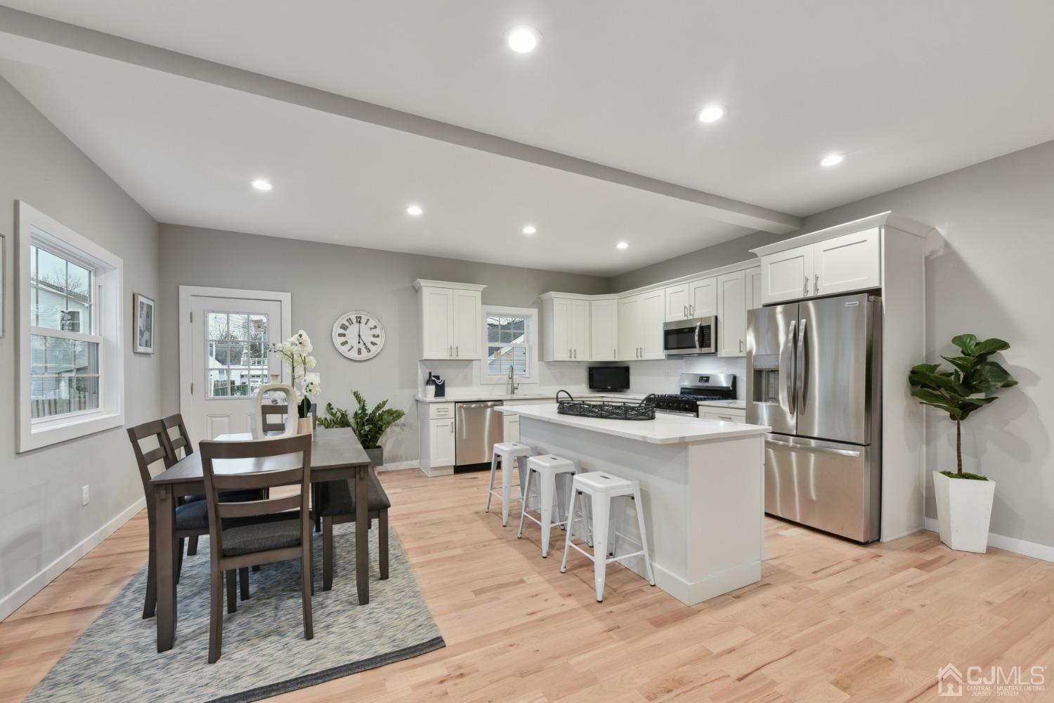 13 Albany Street Edison, NJ 08837 - Photo 9 of 26 a kitchen with refrigerator a table and chairs