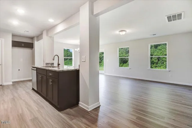 a kitchen with stainless steel appliances sink cabinets and wooden floor